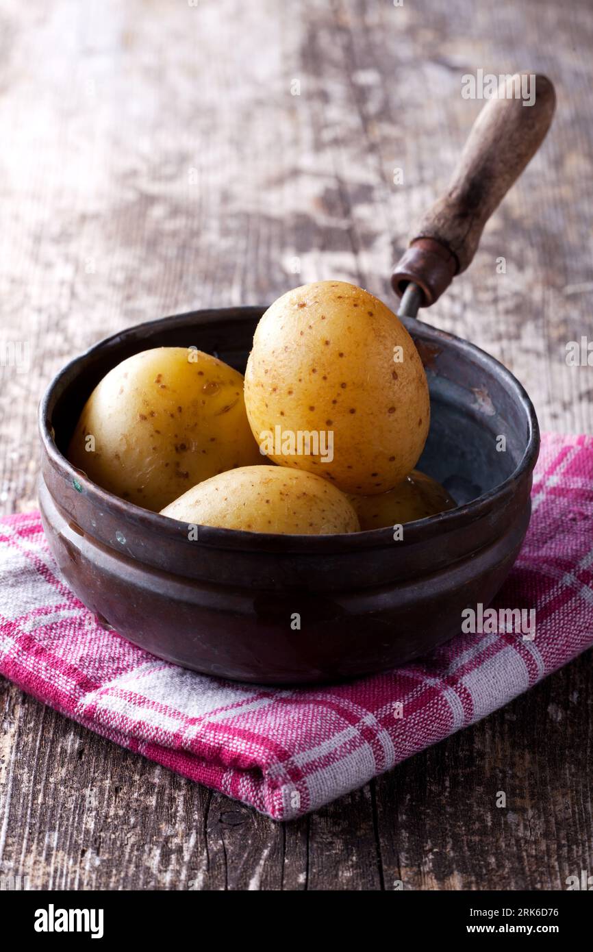 four cooked potatoes in an old pan Stock Photo