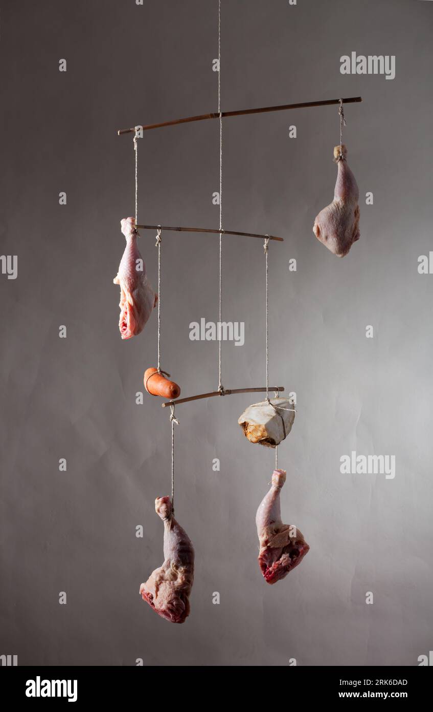 hanging chicken legs on grey Stock Photo