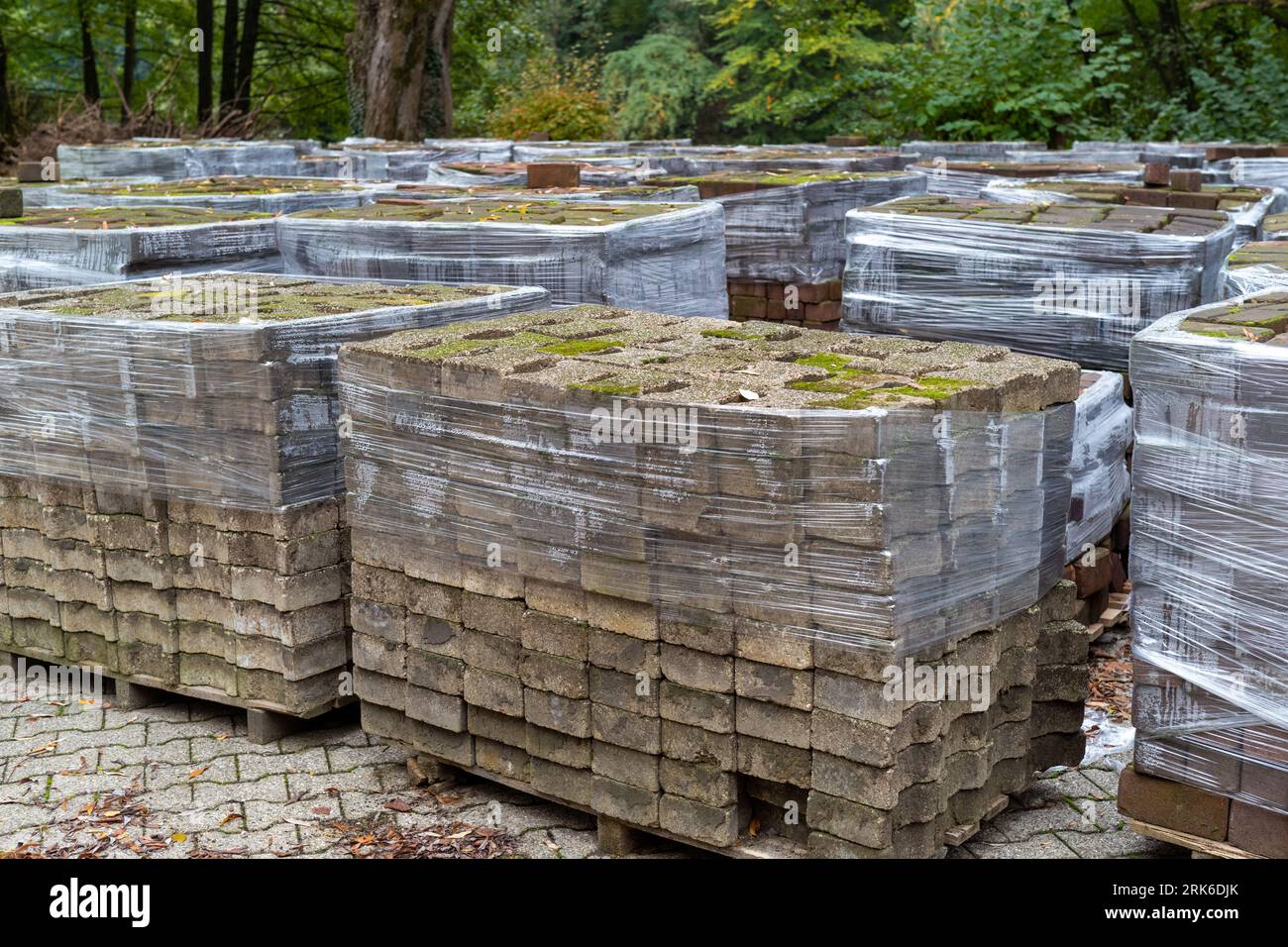 A pile of cardboard boxes stored on pallets in an outdoor location