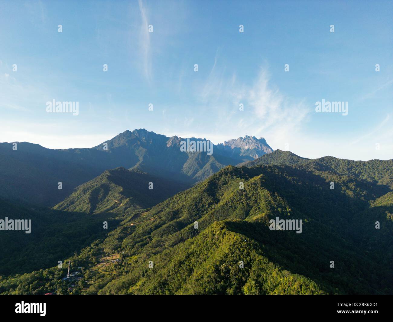 An aerial view of a mountain range covered with green forests on a ...