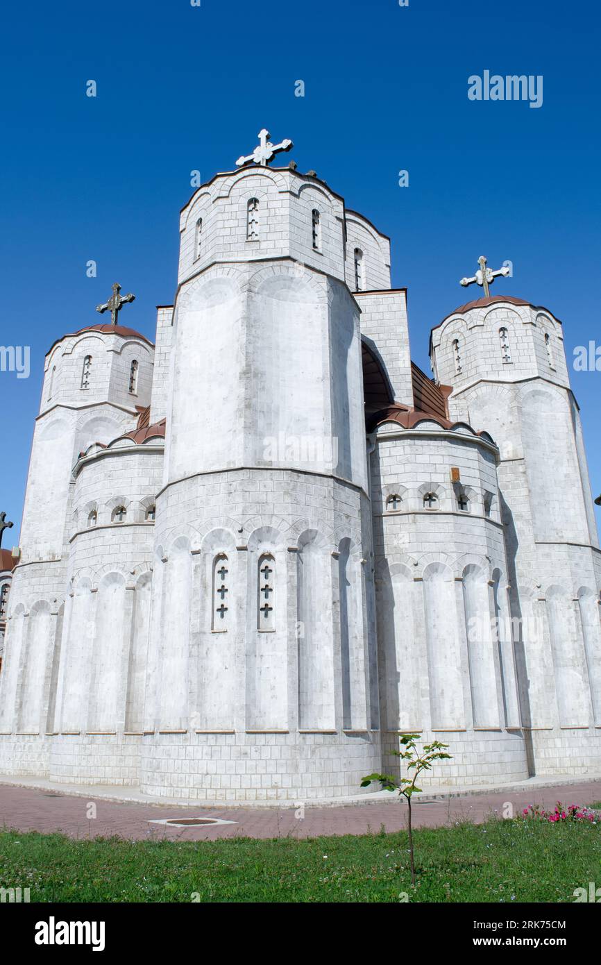 Church of the Three Holy Hierarchs in Skopje, North Macedonia. White stone Orthodox Christian Church with several brass colours domes. Blue summer sky Stock Photo