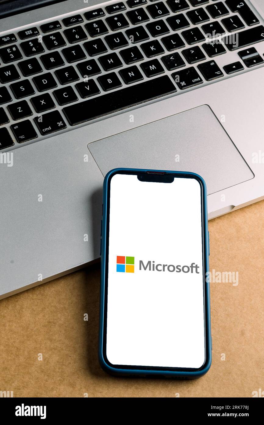 A modern smartphone screen displaying the Microsoft logo. Stock Photo