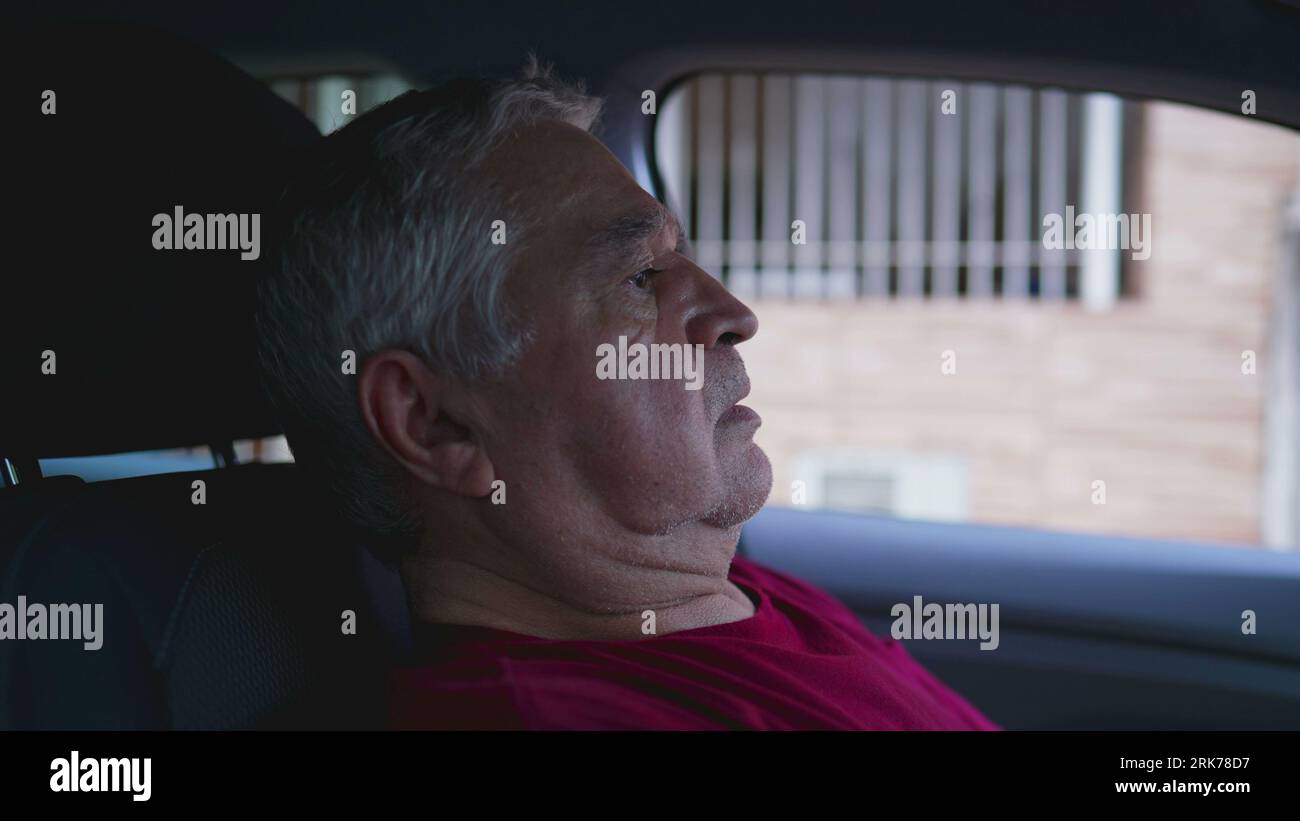 Lonely Senior Man Suffering, Sitting Inside Parked Car leaning on car's steering wheel in quiet despair. Struggling anxious elderly person feeling emo Stock Photo