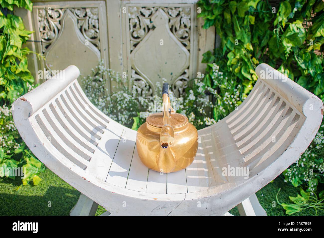 a tea kettle on a chair which is usually used during the traditional bridal shower Stock Photo