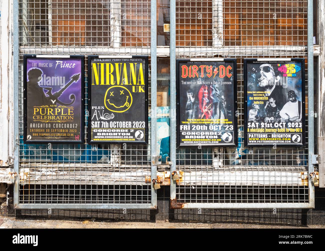 Posters attached to metal grills advertising concerts and gigs by tribute bands in Brighton, East Sussex, UK. Stock Photo