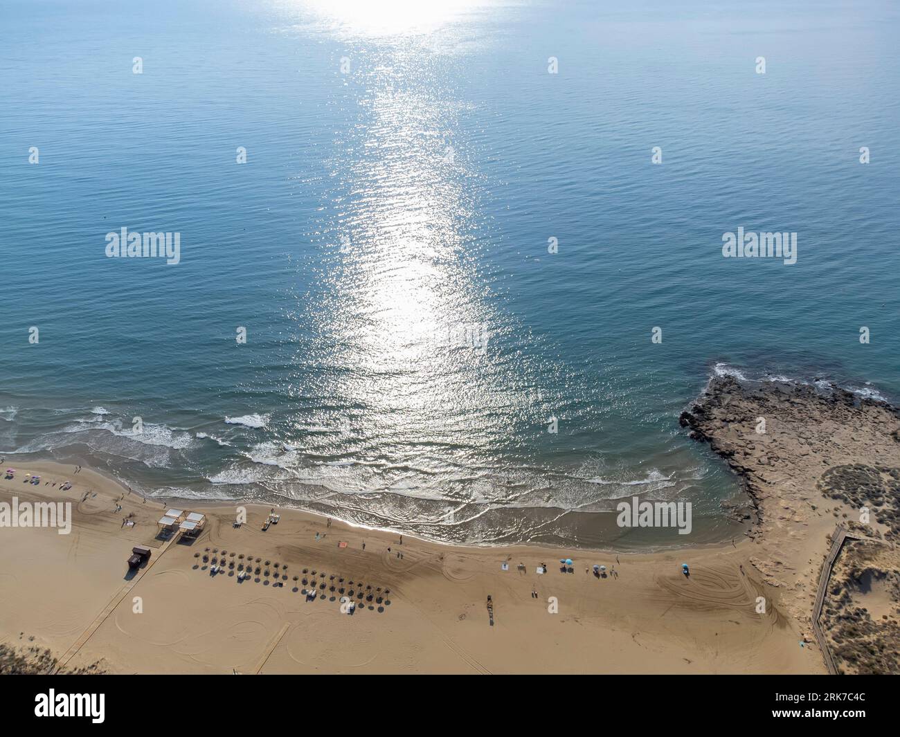with the reflection of the sun on the turquoise waters in the early morning hours, Alcossebre beach, horizontal Stock Photo