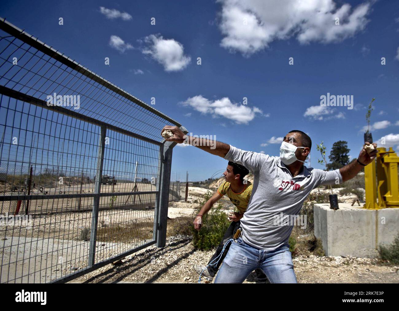 Bildnummer: 53905671  Datum: 30.03.2010  Copyright: imago/Xinhua (100330)-- RAMALLAH, March 30, 2010 (Xinhua) -- A Palestinian protester hurls stones at Israeli soldiers during a demonstration marking land day and against the Israeli separation barrier in the West Bank village of Bodros near Ramallah on March 30, 2010. March 30 marks Land Day, the annual commemoration of protests in 1976 against Israel s appropriation of Arab-owned land in the Galilee. (Xinhua/Fadi Arouri) (axy) (3)RAMALLAH-ISRAEL-DEMONSTRATION PUBLICATIONxNOTxINxCHN Palästina Palästinenser Steinwurf Schleuder Wurfschleuder St Stock Photo
