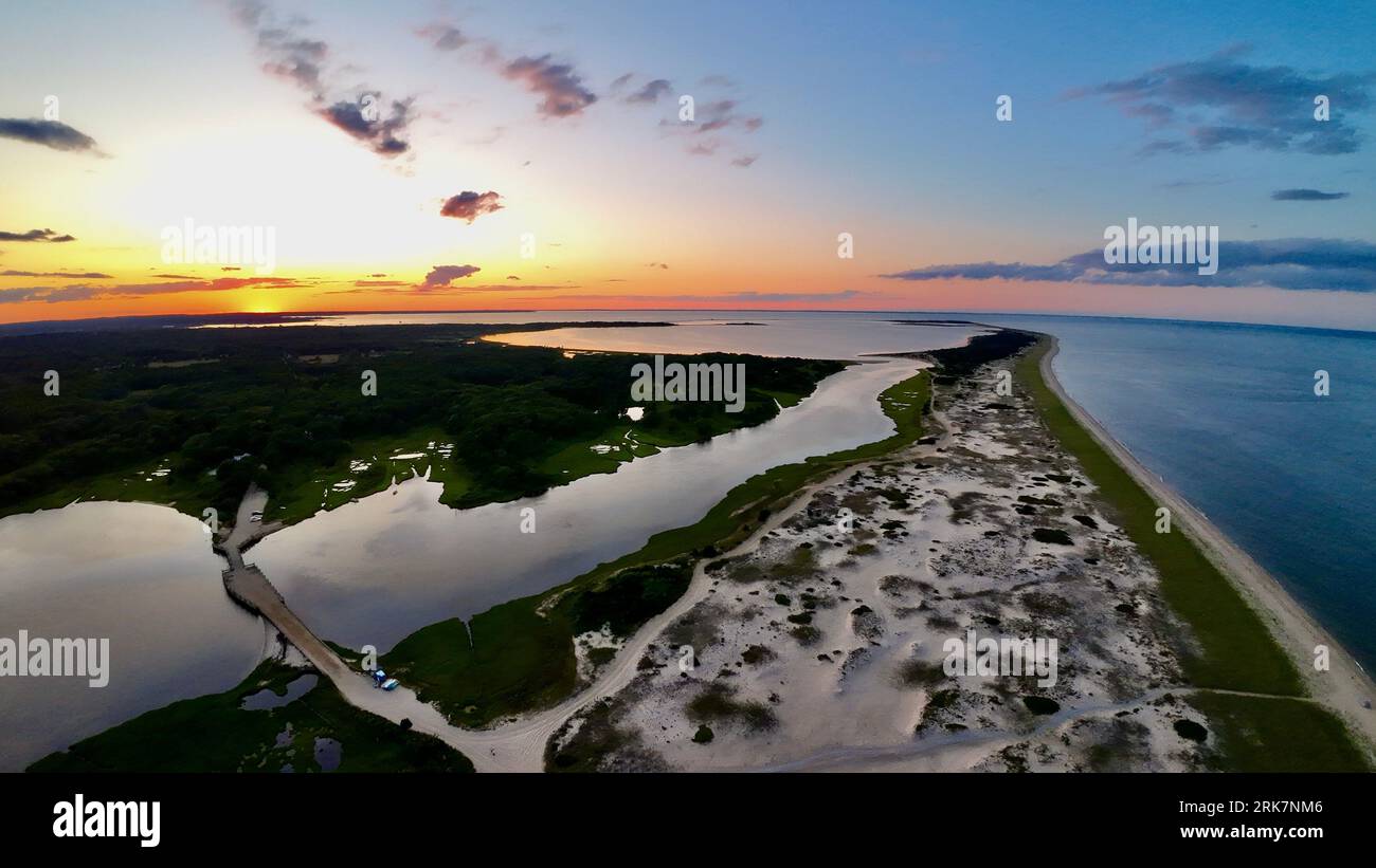 An aerial view of a tranquil lake surrounded by a lush shoreline, with ...