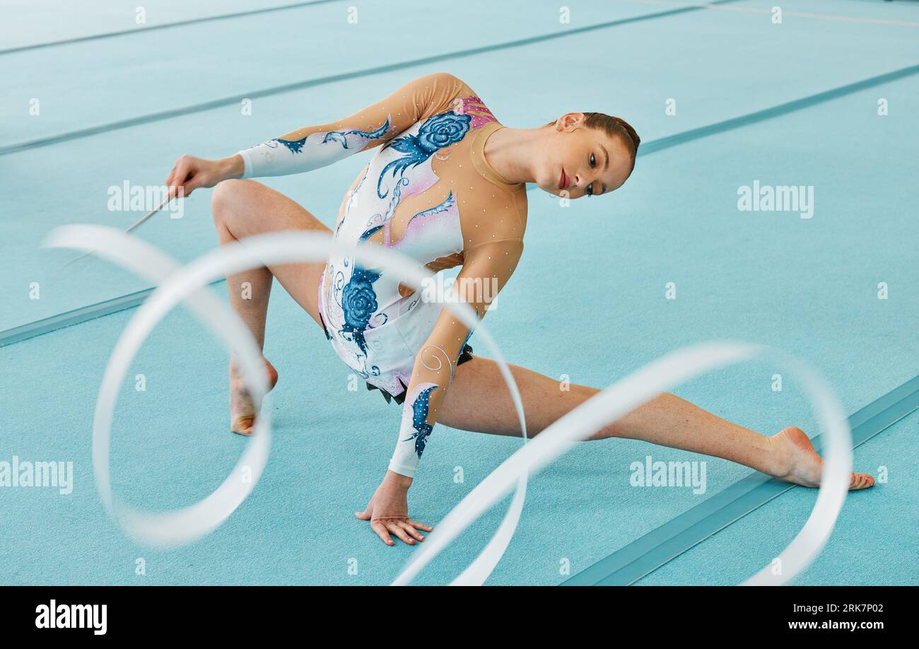 Woman, ribbon gymnastics and action for performance, sports competition