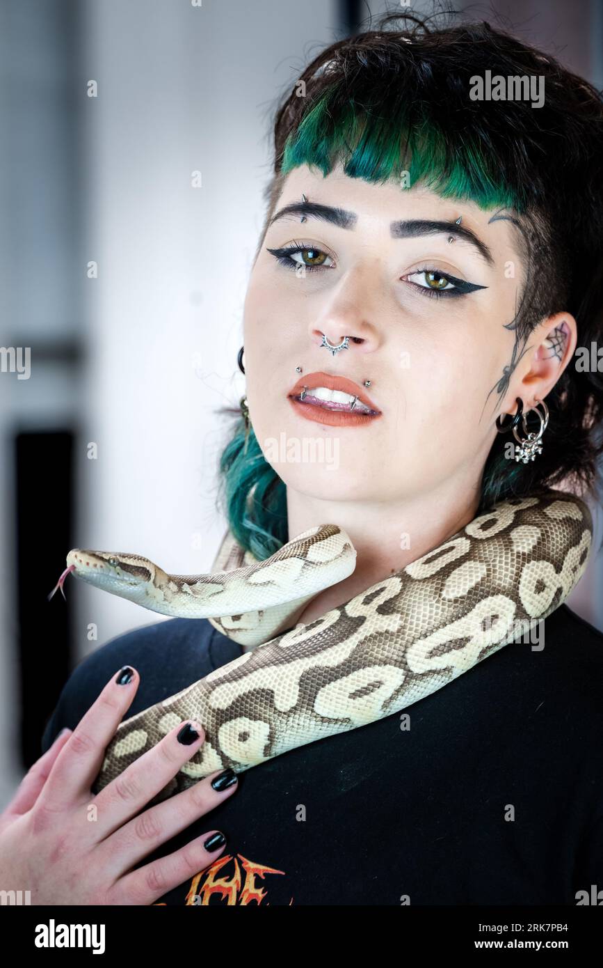A young woman with a unique sense of style is confidently posing with a ...