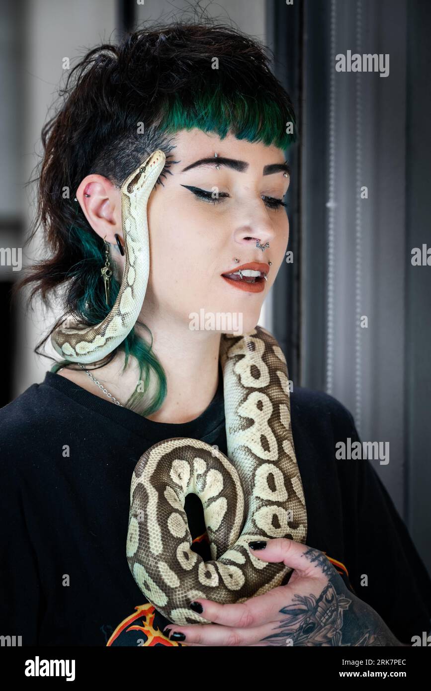 A young woman with a unique sense of style is confidently posing with a ...