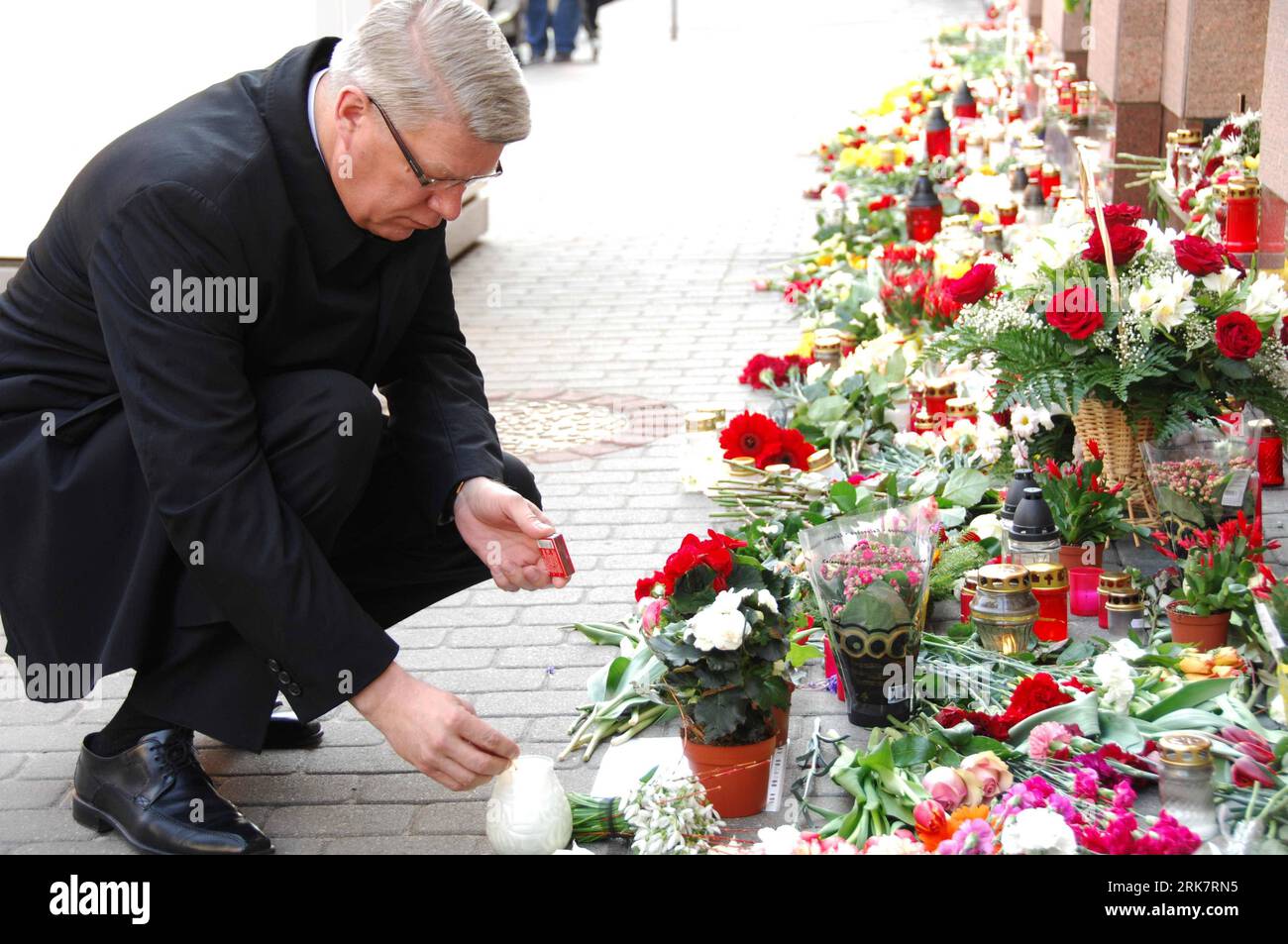 Bildnummer: 53936080  Datum: 12.04.2010  Copyright: imago/Xinhua (100412) -- REGA, April 12, 2010 (Xinhua) -- Latvian President Valdis Zatlers lights the candle to mourn for the death of Polish President Lech Kaczynski in the Saturday plane crash in Russia, outside Poland s Embassy to Latvia in Rega, April 12, 2010. Latvia has announced April 12 as a day of national mourning for the victims of the plane crash. (Xinhua/Yang Dehong) (hdt) (1)LATVIA-RIGA-POLAND-PLANE CRASH-MOURNING PUBLICATIONxNOTxINxCHN People Politik Trauer Gedenken Flugzeugabsturz Absturz Flugzeugunglück Unglück premiumd xint Stock Photo