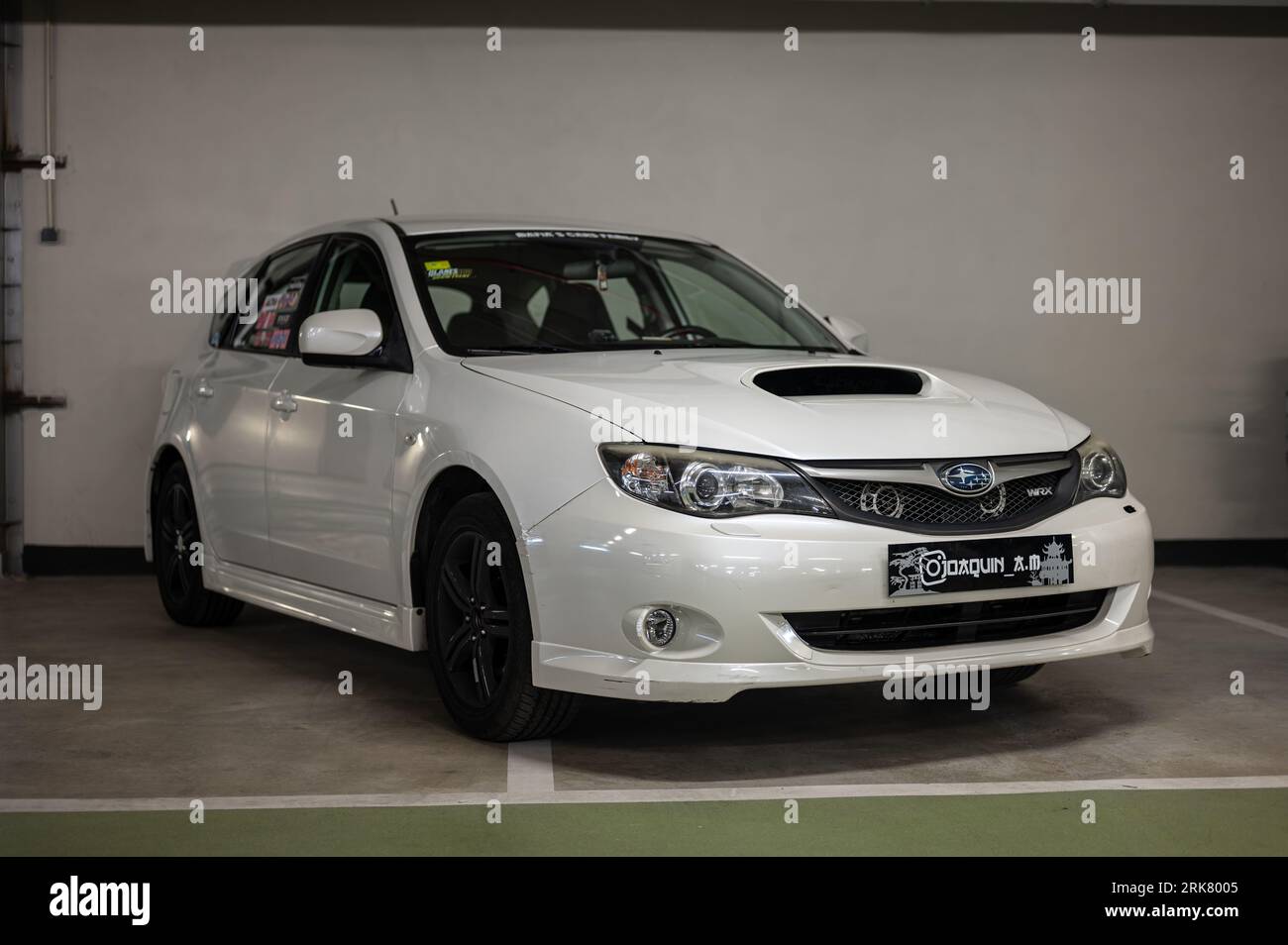 Front view of a Japanese all-wheel drive rally sports car, oclor white third generation Subaru Impreza WRX parked in an indoor parking lot Stock Photo