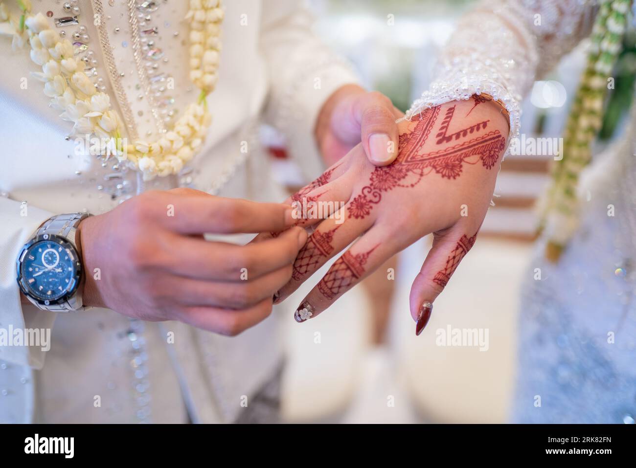 A husband and wife put each other's wedding rings in a traditional
