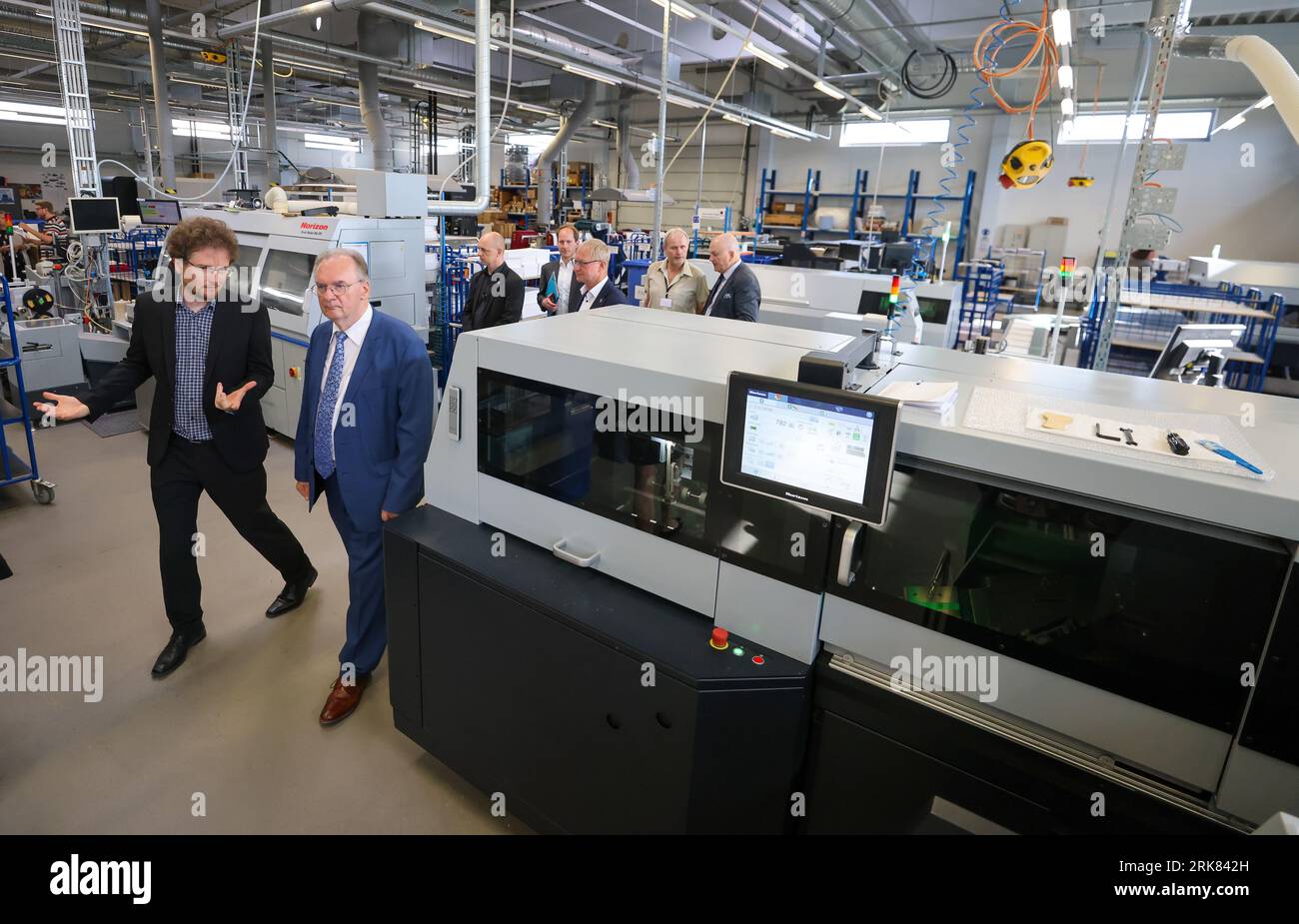 24 August 2023, Saxony-Anhalt, Bitterfeld-Wolfen: Björn Schwarzbach (l), Managing Director of ORWONet, gives Reiner Haseloff (CDU), Minister President of Saxony-Anhalt, a tour of ORWO's production facilities. The former Wolfen film factory, founded in 1909, became 'ORWO' (Original Wolfen) in 1964. After various takeovers in the 1990s, the company attempted to re-enter the market as a large-scale laboratory with the advent of digital photography. For 20 years, the company has now been producing for direct customers, drugstore chains and private labels, as well as end customers. The product rang Stock Photo