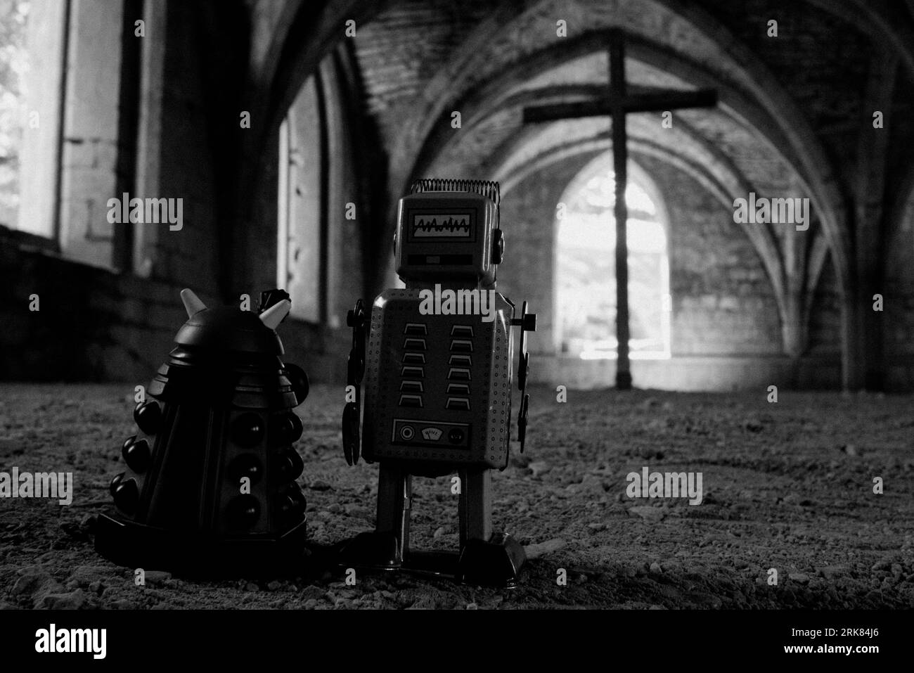 A vintage-style metal robot and a smaller robotic companion are standing in front of a grand arched doorway, looking up in admiration Stock Photo