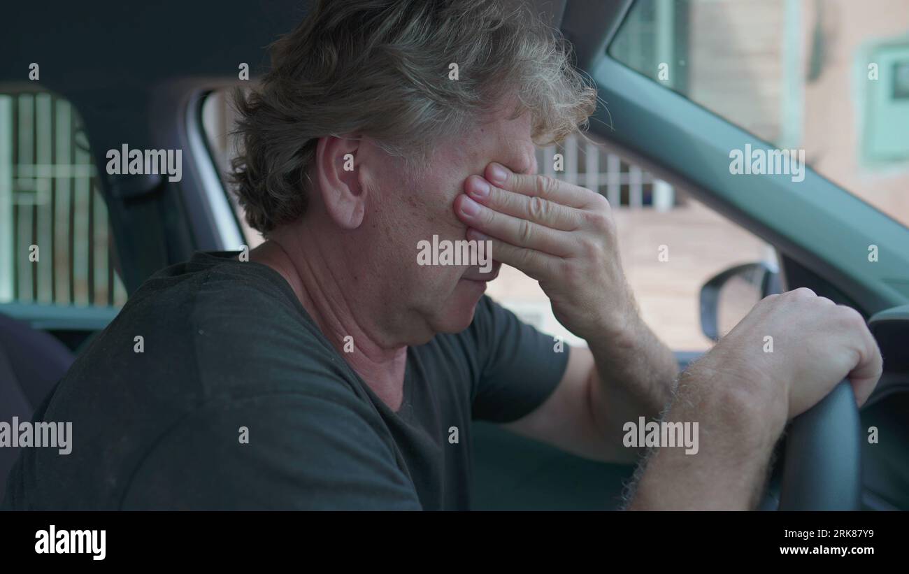 Depressing Car Ride Old man experiencing sadness holding on into car's steering wheel ...