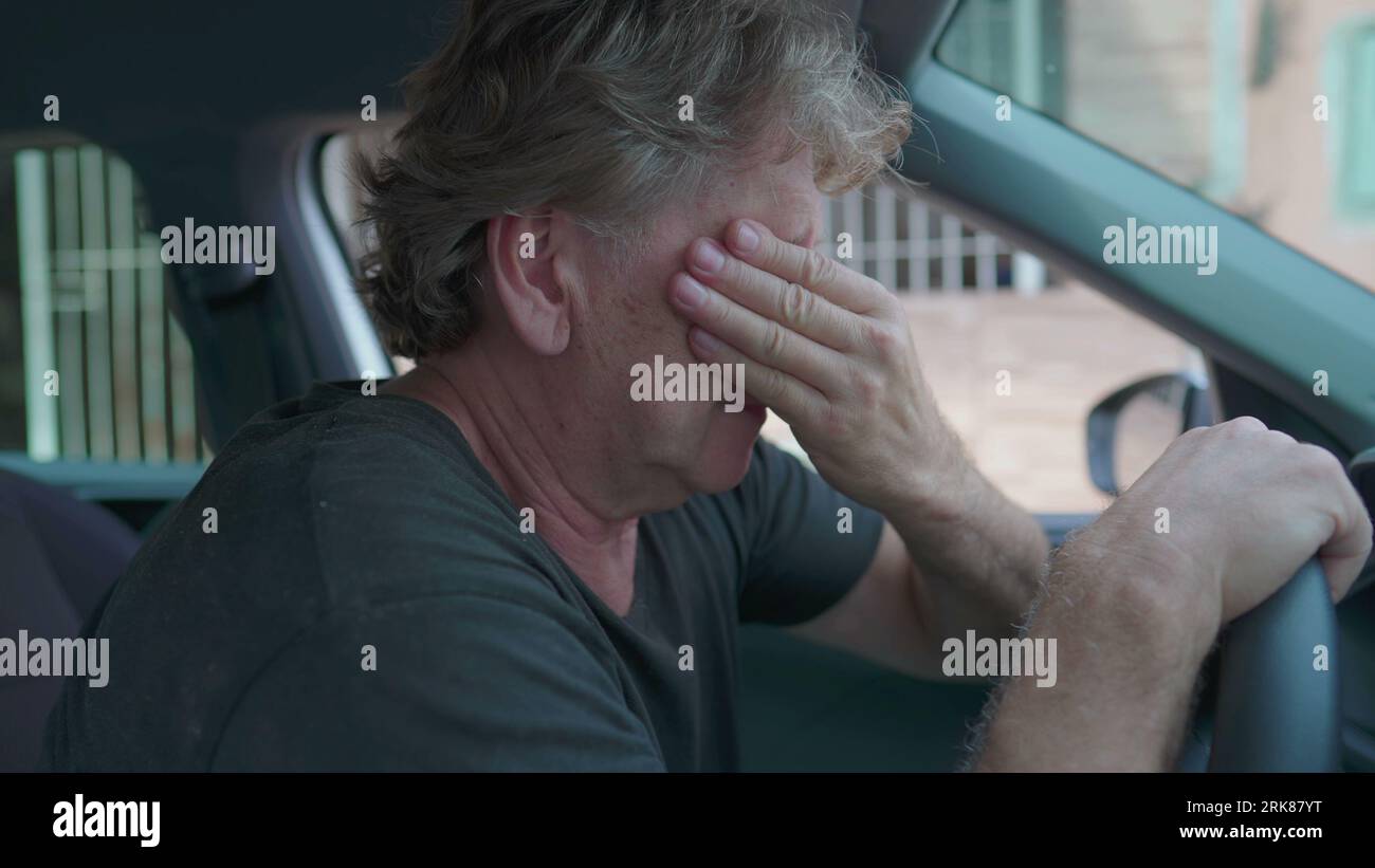 Depressing Car Ride Old man experiencing sadness holding on into car's steering wheel ...
