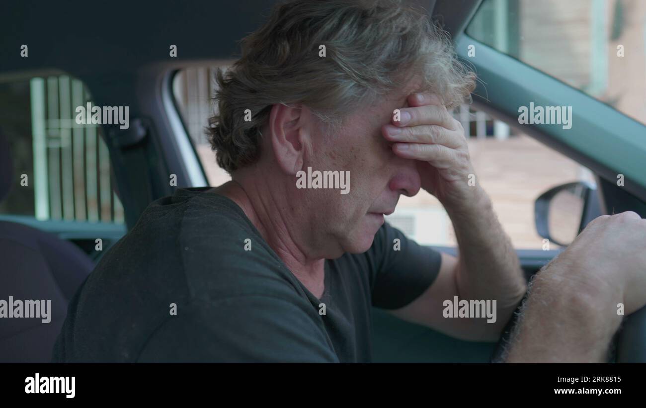 Depressing Car Ride Old man experiencing sadness holding on into car's steering wheel ...