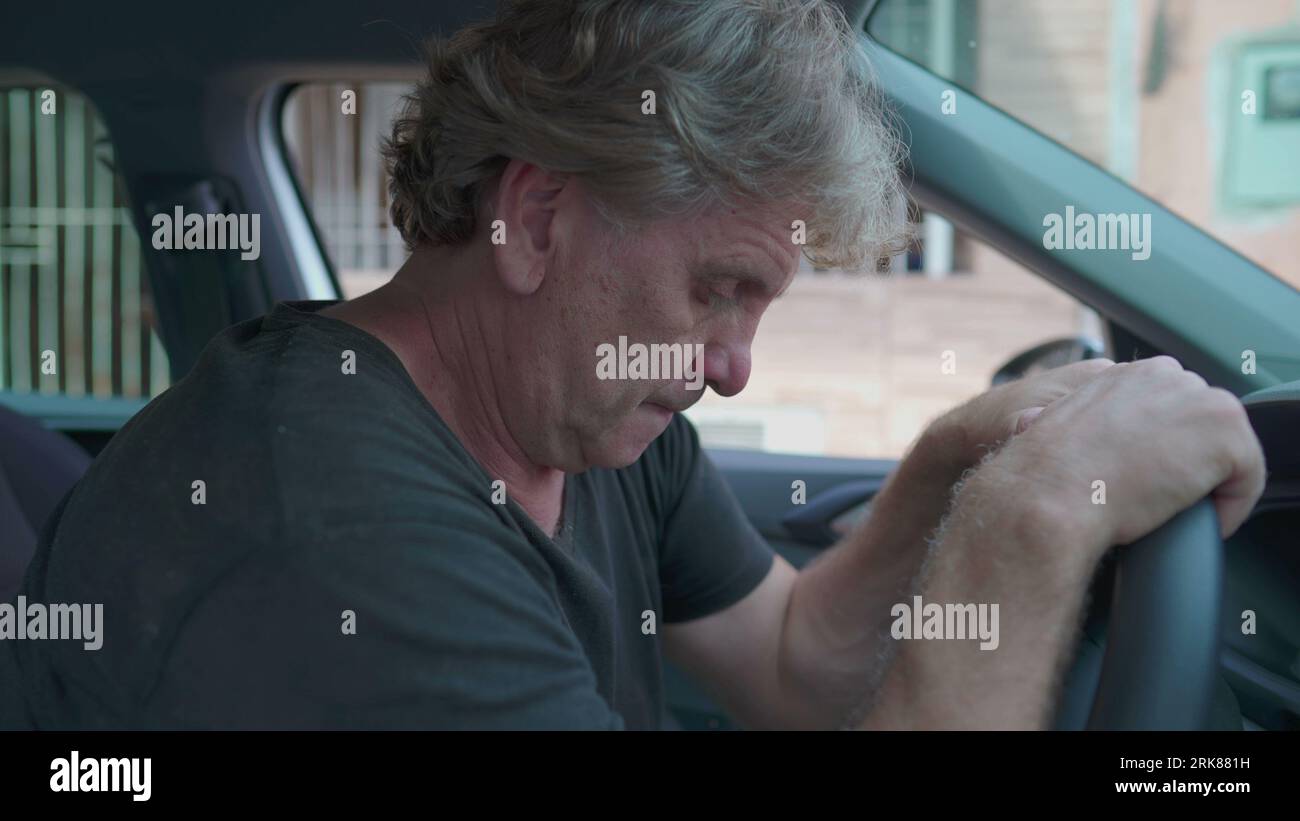 Depressing Car Ride Old man experiencing sadness holding on into car's steering wheel ...