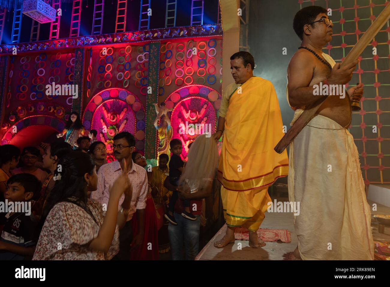 Howrah, West Bengal, India - 3rd October, 2022 : Hindu Priest blessing praying devotees with chamor, fly whisk fan inside Durga Puja pandal. Ashtami. Stock Photo