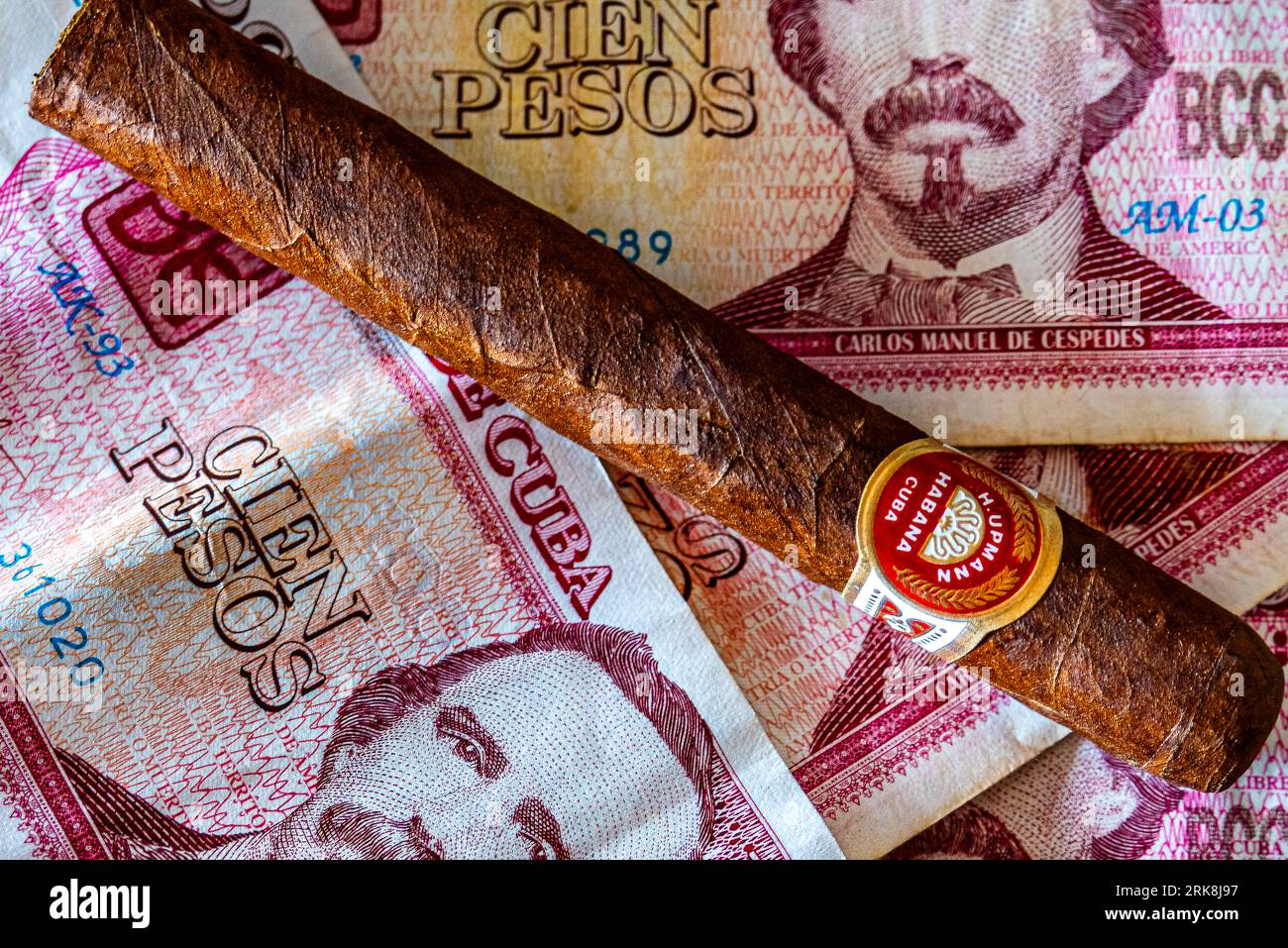 Cuba. Cuban pesos money and cigar. Associations with Cuba. Holidays on the beautiful island of Cuba. Stock Photo