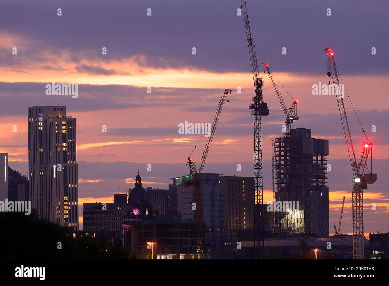 Sunrise in Leeds City Centre with tower cranes working on various