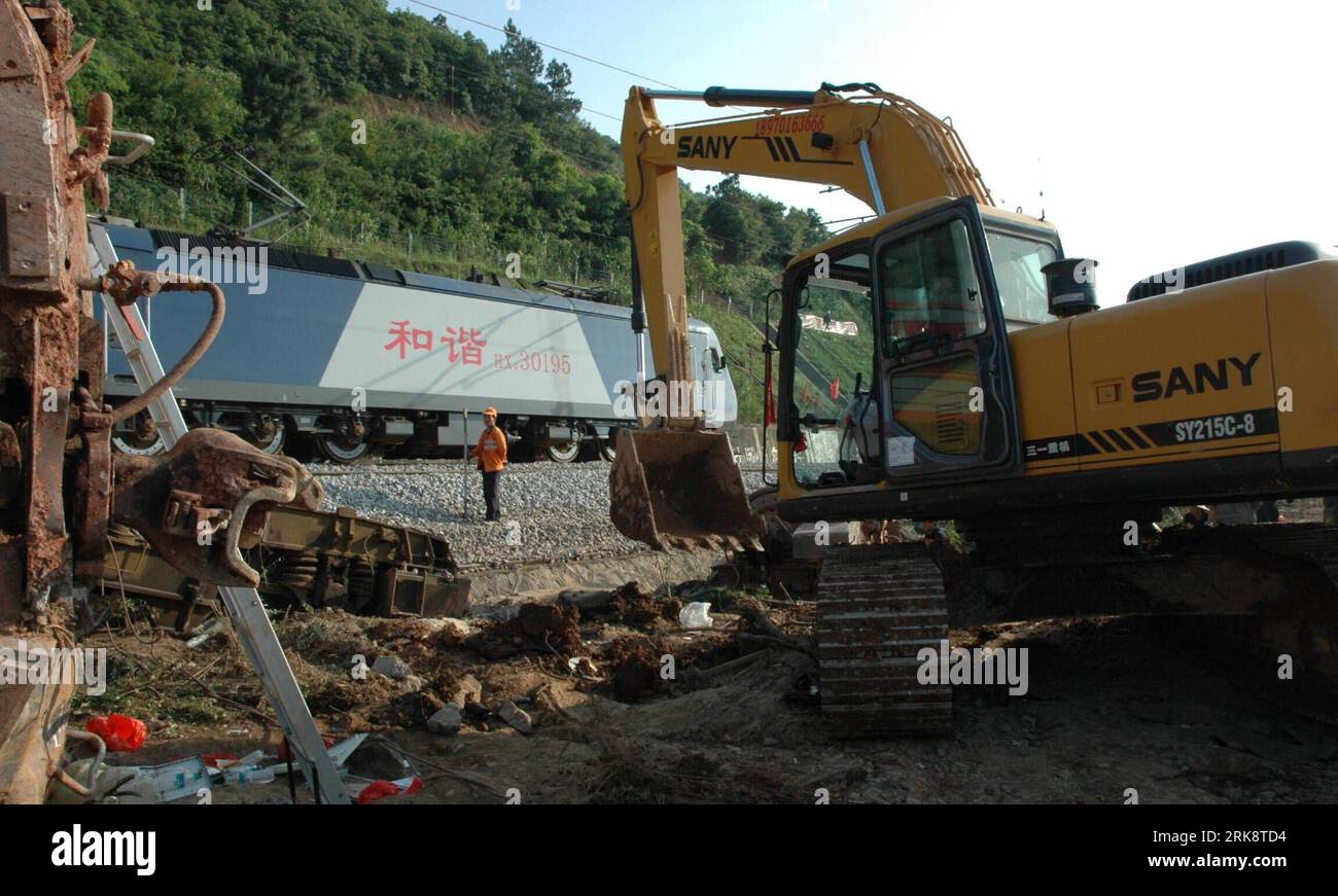 Train track is covered in mud and debris. The train tracks are wet