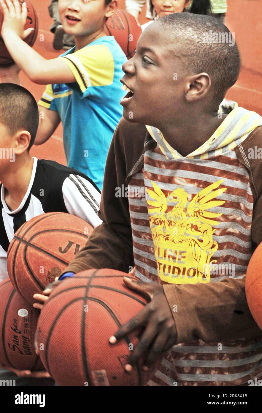 Bildnummer: 54080501  Datum: 26.05.2010  Copyright: imago/Xinhua (100527) -- YIWU, May 27, 2010 (Xinhua) -- Muhammed plays basketball at school, in Yiwu, east China s Zhejiang Province, May 26, 2010. Muhammed, 11 years old, and his sister Kichh, 8 years old, came to Yiwu 5 years ago with their parents who run businesses here. They entered a local school successively in 2007 and 2008, and they are very fond of Chinese culture. (Xinhua/Tan Jin) (lyi) (9)CHINA-YIWU-SENEGALESE CHILDREN (CN) PUBLICATIONxNOTxINxCHN kbdig xkg 2010 hoch o0 Gesellschaft Land Leute o00 Einwanderer, Kind    Bildnummer 54 Stock Photo