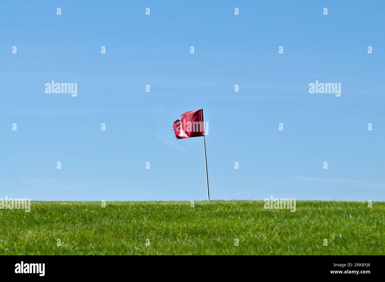 Golf hole waving flag on horizon. Very small golf club Búřov Valašská Bystřice in countryside in Czech republic. Negative space for text. Stock Photo