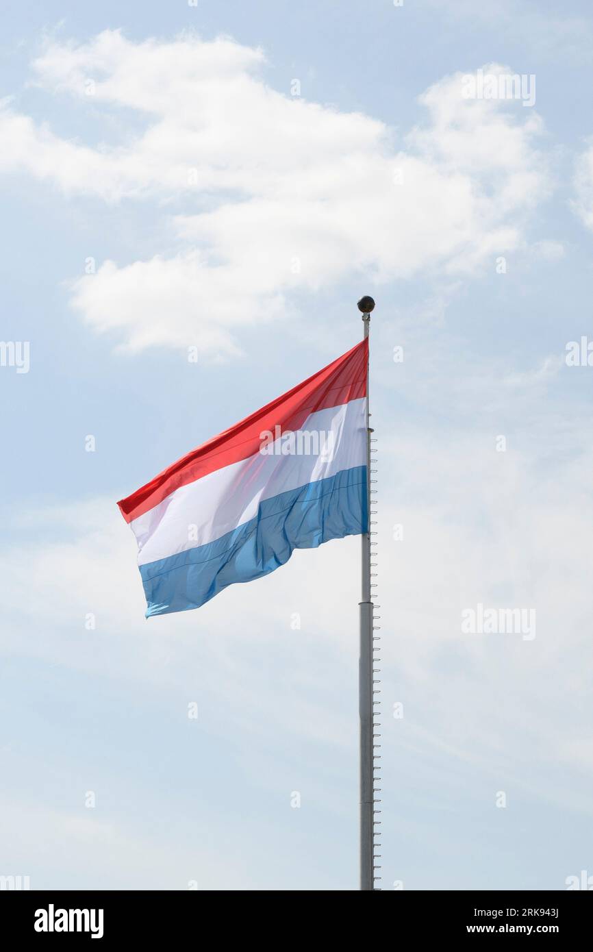 Flag of the Kingdom of Luxembourg - fluttering in the wind against a blue sky, natural photography Stock Photo