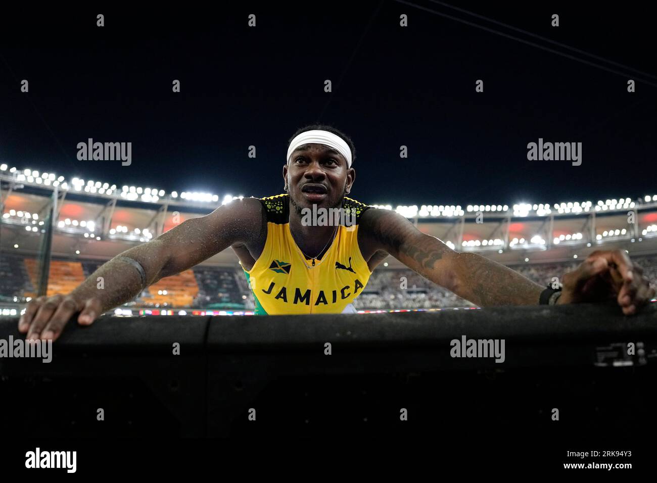 Candice Mcleod, of Jamaica, talks to his coach after competing in the