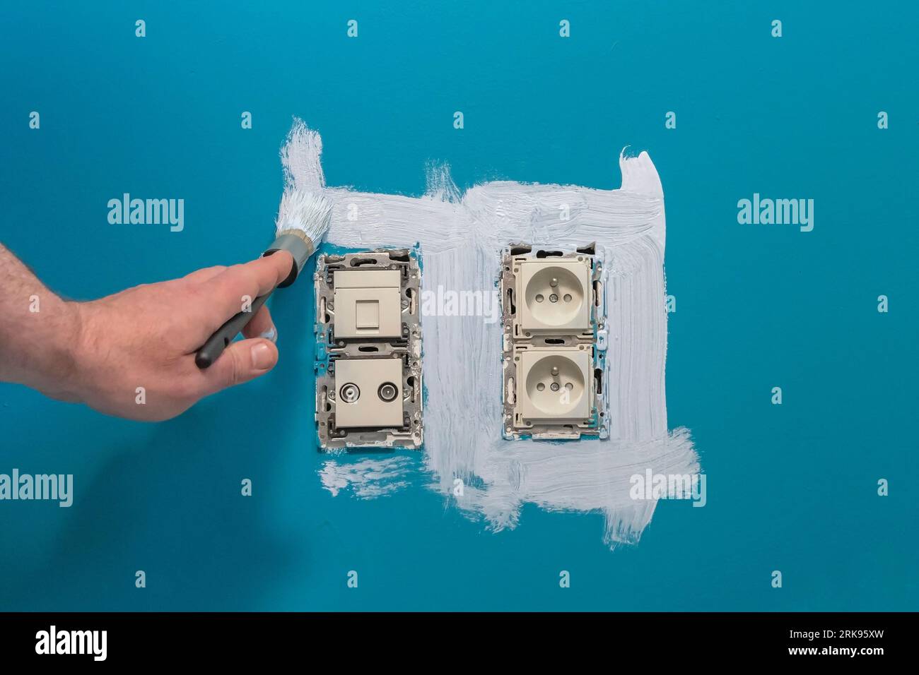 Painting around electrical outlets on the wall. Removed frame of power