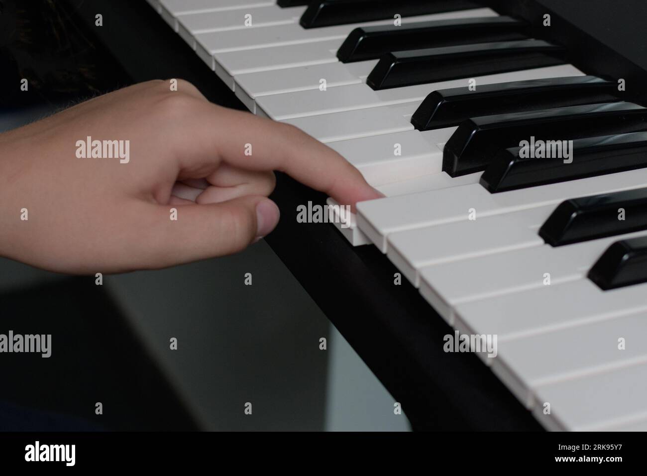 Piano keys one finger touching. Music school lessons. Playing lessons