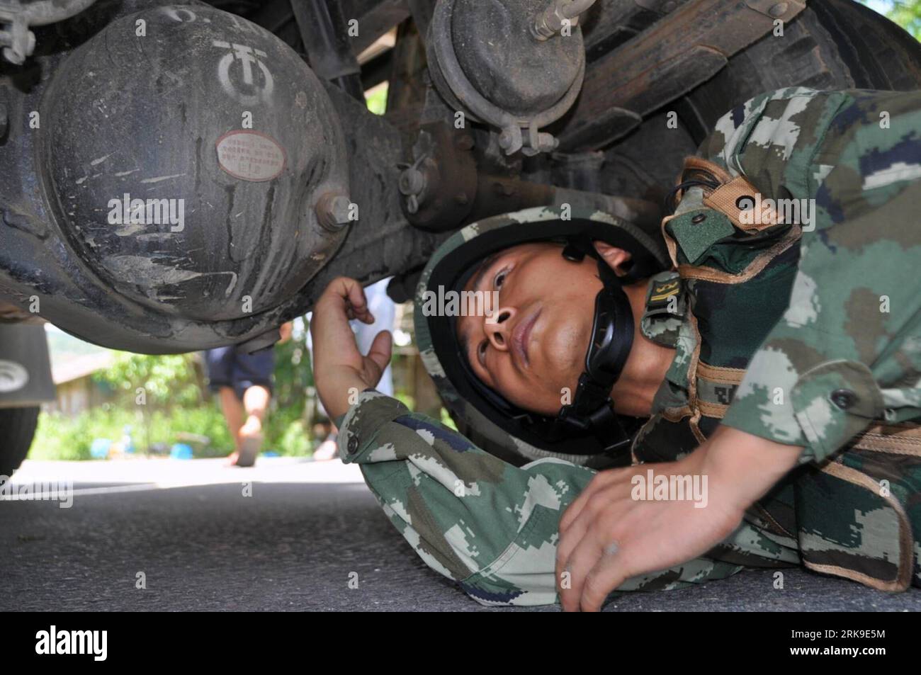 Bildnummer: 54179776  Datum: 24.06.2010  Copyright: imago/Xinhua (100627) -- XISHUANGBANNA, June 27, 2010 (Xinhua) -- An armed Police officer with the Narcotics Enforcement Inspection Station of the Xishuangbanna Prefectural Public Security Frontier Detachment checks through the chassis of a vehicle during the operation of rounding up drugs and traffickers on road outpost, during a regular crackdown on a drug- making and trafficking along the Sino-Myanmar border, 2 days ahead of the International Day Against Drug Abuse and Illicit Trafficking, at Xishuangbanna Dai Autonomous Prefecture, southw Stock Photo