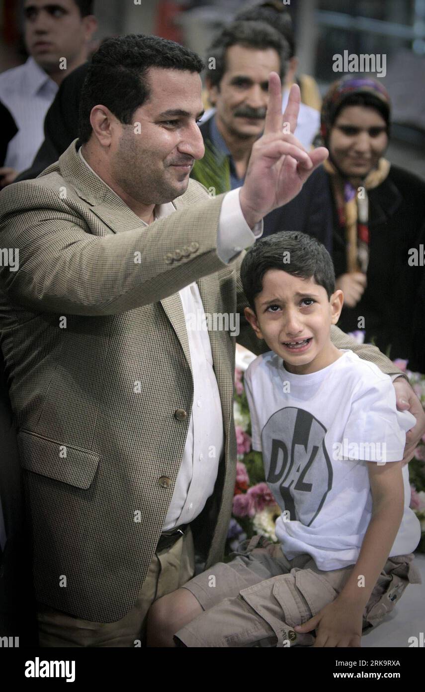 (100715) -- TEHRAN, July 15, 2010 (Xinhua) -- Iranian scholar Shahram Amiri with his son   gestures to people as he arrived in Tehran, July 15, 2010. Shaharm Amiri, 32, who arrived in Tehran early in the morning, told a news conference that he was kidnapped by the CIA and the abduction was part of the U.S. campaign to add political pressures to Iran. (Xinhua/Ahmad Halabisaz) (zhs) (1)IRAN-SCHOLAR-SHAHRAM AMIRI-RETURN PUBLICATIONxNOTxINxCHN Stock Photo