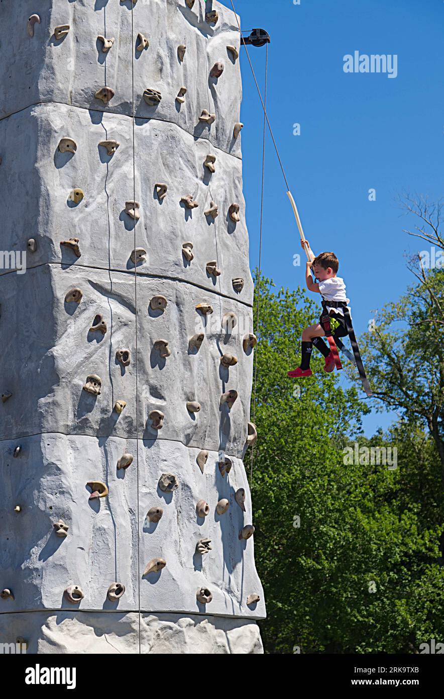 A boy  on the rock-climbing wall at the Marshfield Fair.  Marshfield, Massachusetts, USA Stock Photo