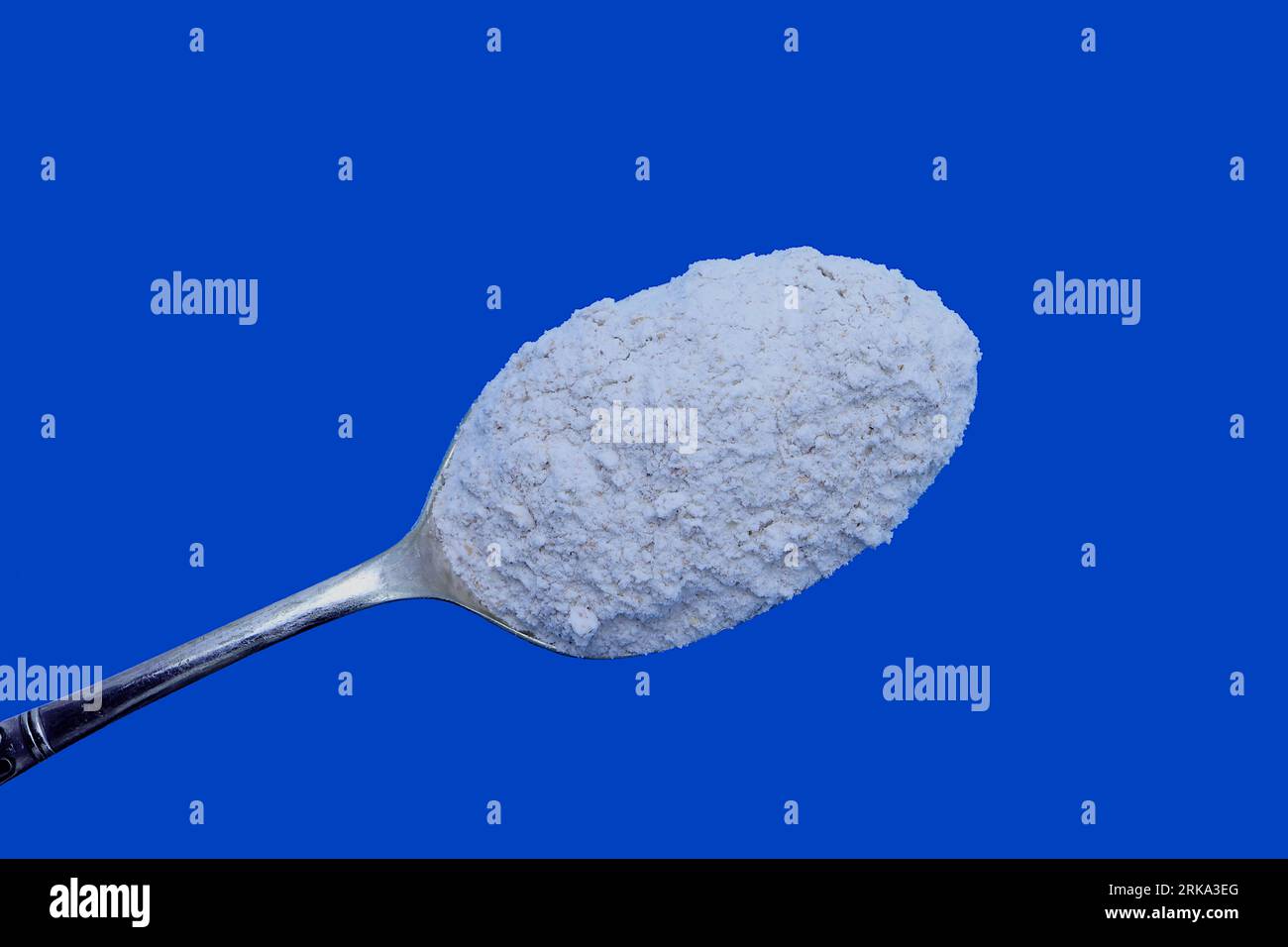 Home baking ingredients: Still life of wholemeal baking flour. Horizontal frame, blue background, copy space. Stock Photo