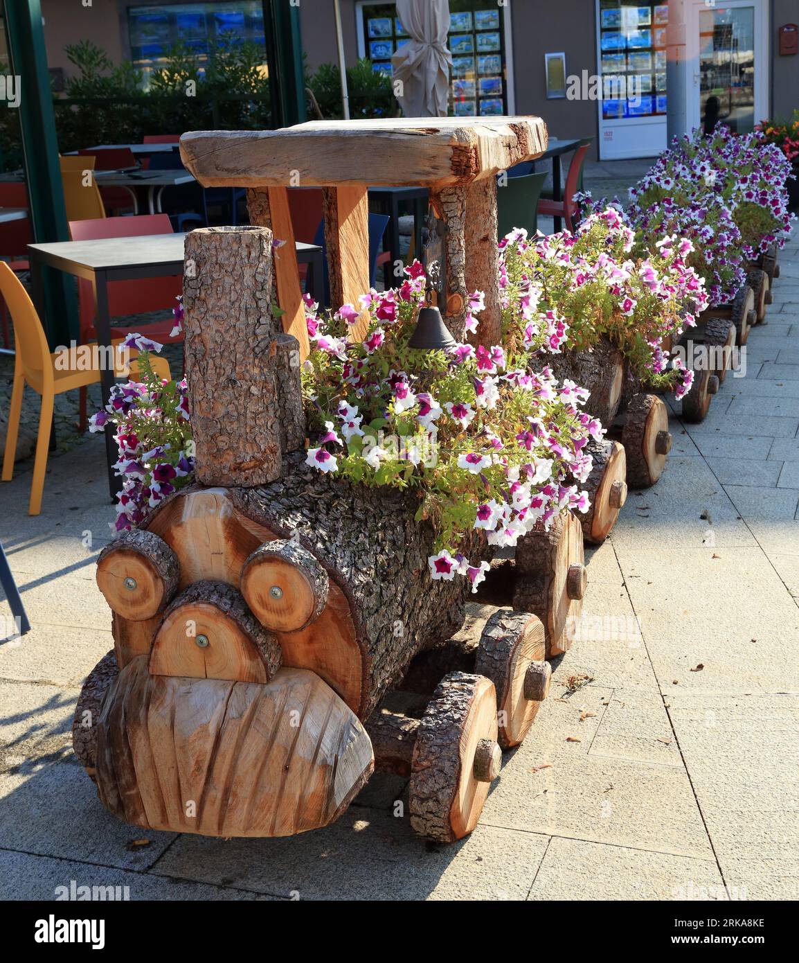 Wooden flower train in Colico town, Lake Como (Lago di Como), Italy. Ristorante Il Bizzarro restaurant. Choo Choo Train Planter Stock Photo