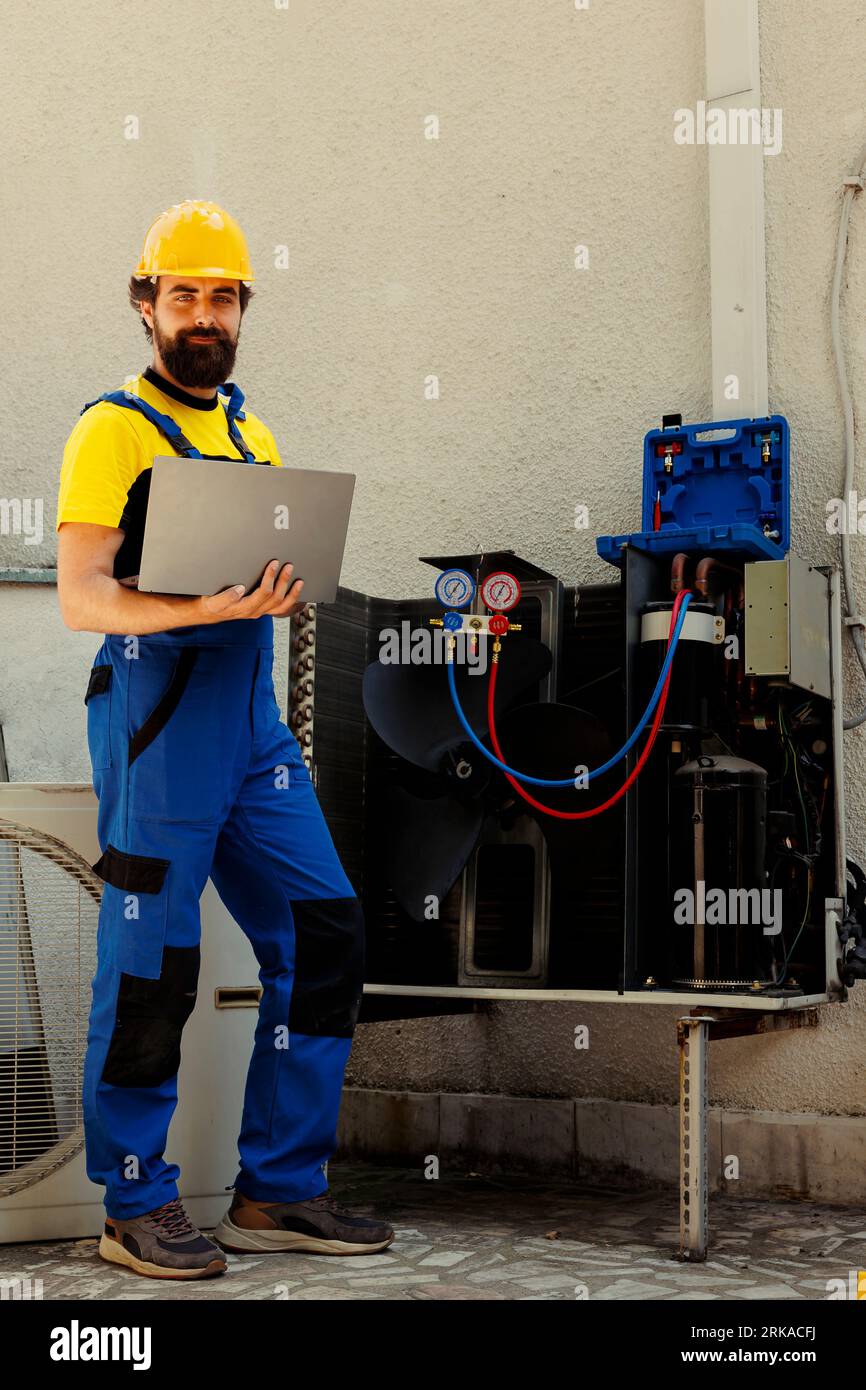 Portrait of smiling knowleadgeable engineer working on external hvac