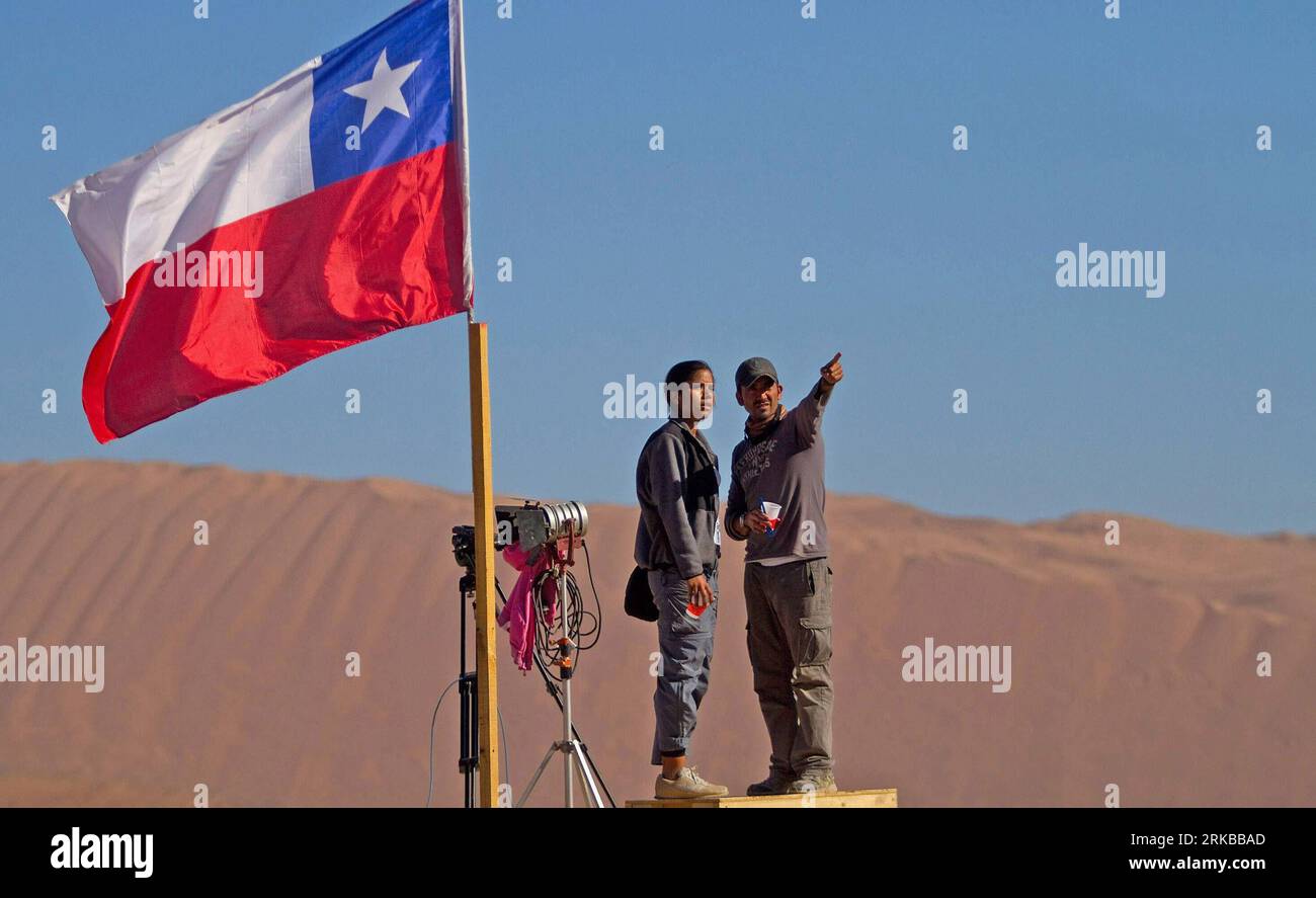 Bildnummer: 54529718 Datum: 10.10.2010 Copyright: imago/Xinhua (101012) -- SAN JOSE (CHILE), Oct. 12, 2010 (Xinhua) -- Two journalists work near the San Jose copper mine in the Atacama Desert, Chile Oct. 10, 2010. The operation to lift out 33 miners trapped for over two months in northern Chile will kick off early Wednesday, Mining Minister Laurence Golborne said Monday. (Xinhua/Martin Zabala) (lmz) CHILE-MINE ACCIDENT-RESCUE-MEDIA PUBLICATIONxNOTxINxCHN Gesellschaft Chile San Jose Mine Bergbau Grubenunglück Rettung Bergleute Bergung kbdig xcb 2010 quer premiumd o0 Fahne, Nationalfahne Bi Stock Photo