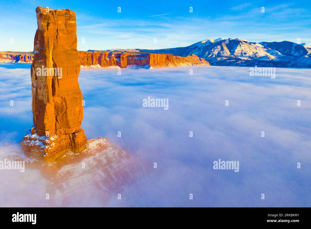 Castle Rock rises above winter fog, Castle Vallery Utah, Near Moab, Coloraod River, A 'glory' from sunlight on fog appears, Lqa Sal MOuntains beyond Stock Photo