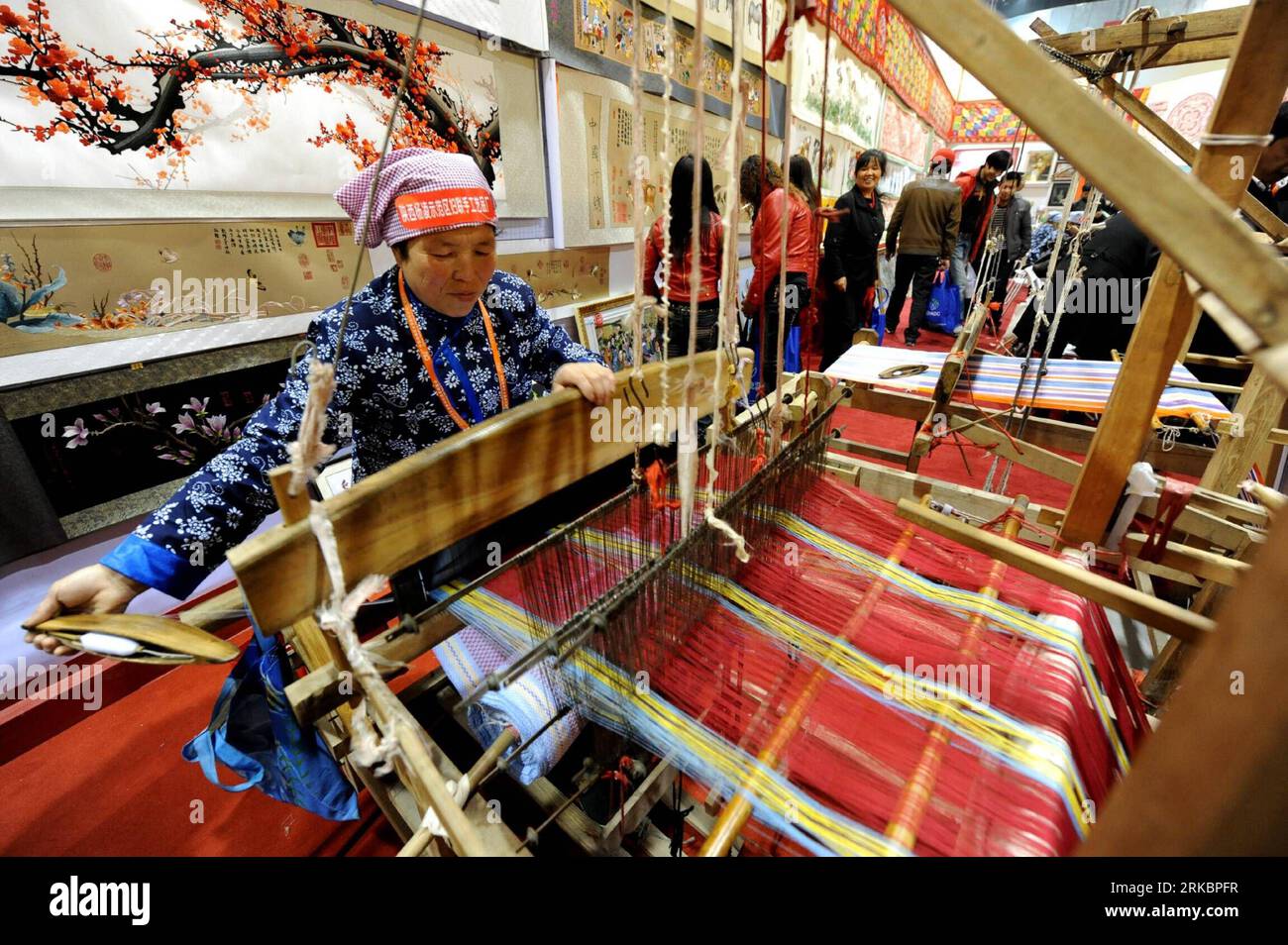 Bildnummer: 54591416  Datum: 02.11.2010  Copyright: imago/Xinhua (101102) -- YANGLING, Nov. 2, 2010 (Xinhua) -- Craftswomen demonstrate hand weaving at an agricultural exhibition in Yangling, northwest China s Shaanxi Province, Nov. 2, 2010. The traditional hand weaving originated in Shaanxi has a history of thousands years, and the industry is reviving in Shaanxi as the textiles win popularity among buyers for bright colors and the organic quality. (Xinhua/Liu Xiao) (zhs) CHINA-SHAANXI-HANDWEAVING (CN) PUBLICATIONxNOTxINxCHN Gesellschaft Arbeitswelten Frauen Weben Weberei Handwerk Webstuhl kb Stock Photo