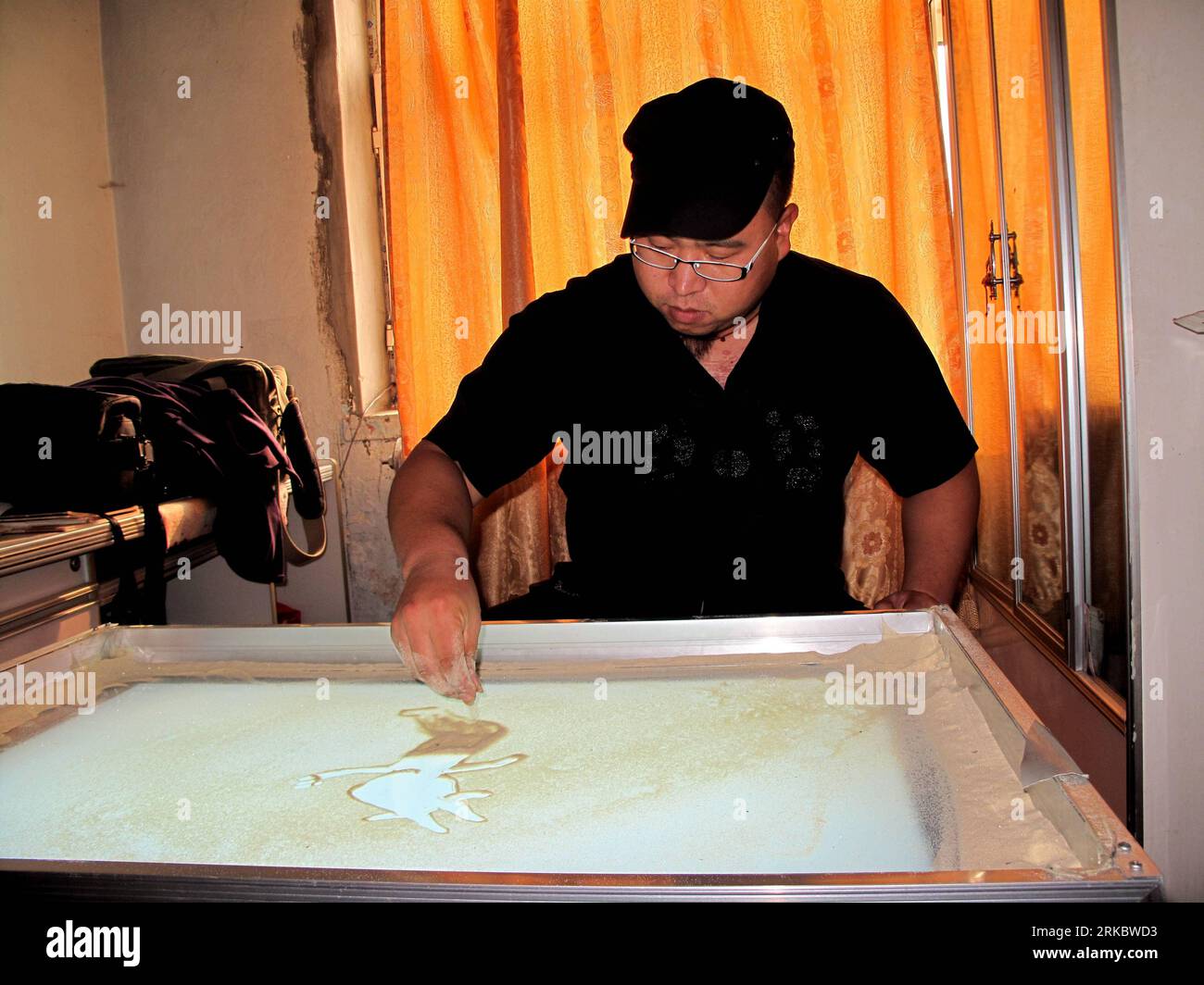 Bildnummer: 54616390  Datum: 06.11.2010  Copyright: imago/Xinhua (101106) -- JILIN, Nov. 6, 2010 (Xinhua) -- Liu Yong makes a piece of sand animation about the upcoming Guangzhou 2010 Asian Games at home in Jilin, a city of northeast China s Jilin Province, Nov. 6, 2010. The 31-year-old Liu, beginning to learn sand animation in 2009, is now a professional sand animation artist performing around the country. (Xinhua/Zhu Wanchang) (wxy) CHINA-JILIN-SAND ANIMATION-GUANGZHOU 2010 ASIAN GAMES (CN) PUBLICATIONxNOTxINxCHN Gesellschaft kbdig xkg 2010 quer Aufmacher premiumd o0 Kunst Malerei Sand Sandm Stock Photo