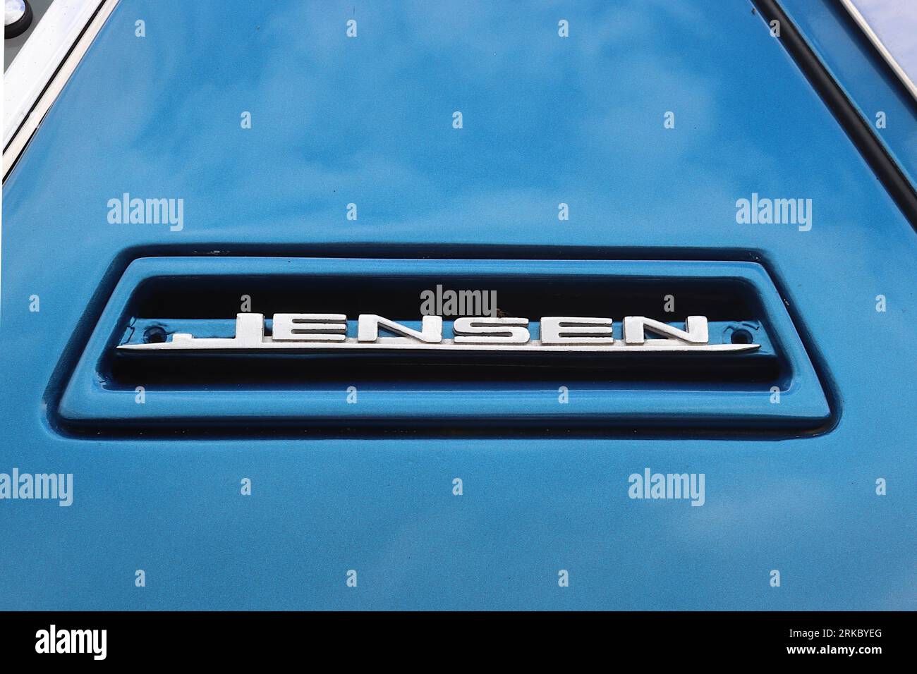 Iconic Jensen B pillar badge requiring refurbishment on a metallic blue Interceptor sports car, displayed on a project car awaiting full restoration, Stock Photo