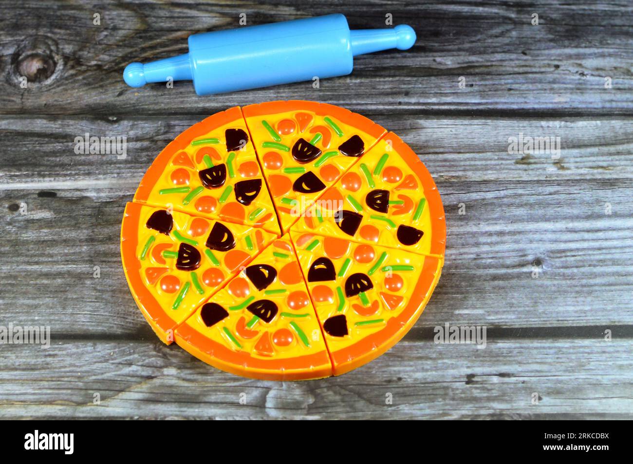 set of pizza toy for kids, slices of unreal pizza for playing games for children isolated on wooden background, gaming concept for kids, selective foc Stock Photo