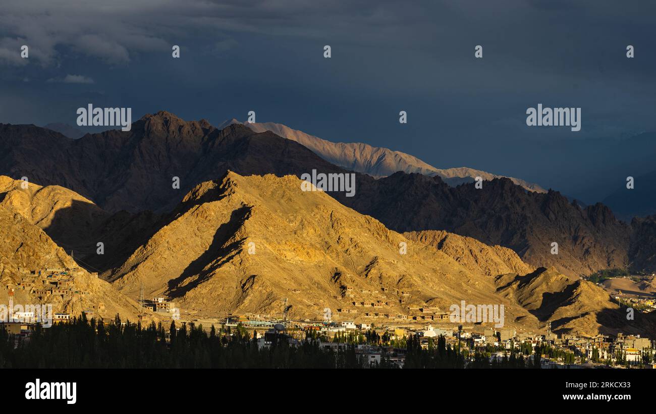 Mountains, clouds and blue sky with Leh town in foreground captured on 10 August 2023 Stock Photo