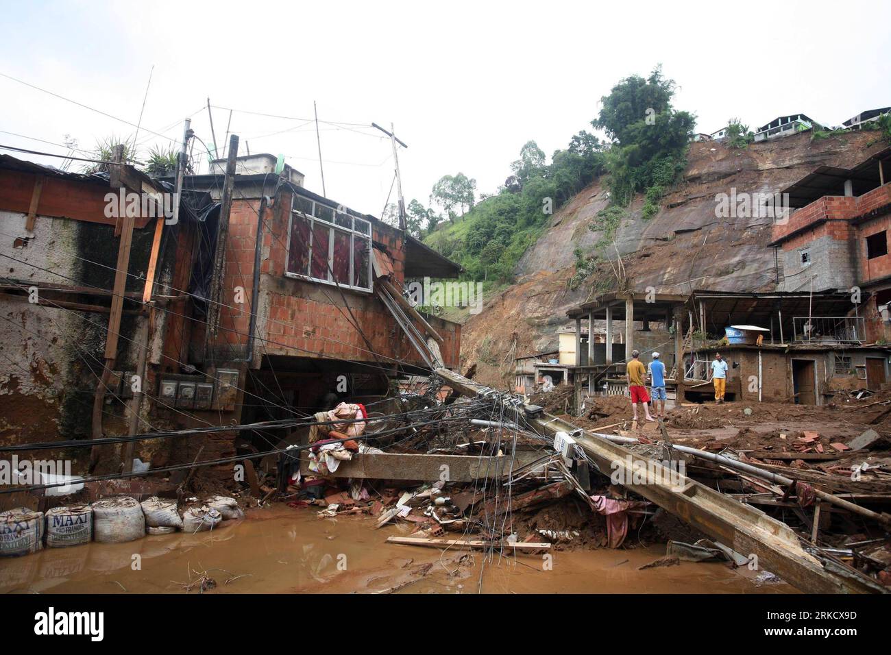 Bildnummer: 54821604  Datum: 15.01.2011  Copyright: imago/Xinhua (110115) -- NOVA FRIBURGO, Jan. 15, 2011 (Xinhua) -- Villagers stand in front of the remains of their homes after a landslide in Nova Friburgo, Brazil, Jan. 15, 2011. According to the local government, the death toll caused by this week s heavy rains and mudslide that hit Brazil s Rio de Janeiro state has reached at least 550. (Xinhua/Agencia Estado) (BRAZIL OUT) (wjd) BRAZIL-MUDSLIDE-FLOOD PUBLICATIONxNOTxINxCHN Gesellschaft Naturkatastrophe Flut premiumd kbdig xmk 2011 quer o0 Erdrutsch, Totale, Gebäude, Wohnhäuser, Zerstörung, Stock Photo