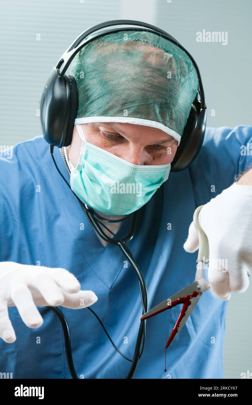 Surgeon with headphones uses a bloody office scissor, hinting at gross negligence. Represents medical malpractice, dangers, and the necessity for prof Stock Photo