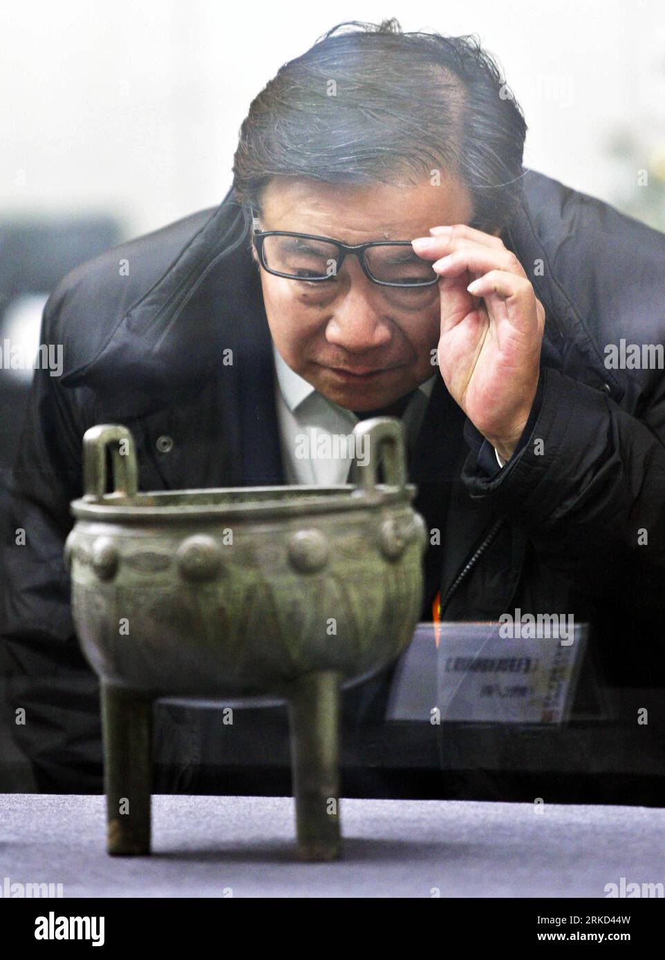 Bildnummer: 54858096  Datum: 20.01.2011  Copyright: imago/Xinhua (110127) -- BEIJING, Jan. 27, 2011 (Xinhua) -- A tourist views an artwork from China s Palace Museum in Art Treasures Museum of the Chinese Nation in Beijing, capital of China, Jan. 20, 2011. China s Palace Museum, located inside the Forbidden City, announced on Wednesday that a seven-year inventory, which began in 2004, reveals the museum s collection includes 1,807,558 objects, providing the first accurate appraisal of the size of the museum s collection. (Xinhua/Zhang Chuandong) (ly) CHINA-BEIJING-PALACE MUSEUM-COLLECTION-APPR Stock Photo